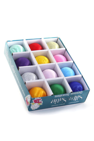 A boxed set of 12 Silkie Satin Christmas decorations in various pastel and bright colors, displayed in a blue and white grid tray on a white background.